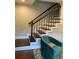 Staircase with hardwood steps, dark metal railing, and a chair at 2170 Beecher Sw Cir, Atlanta, GA 30311
