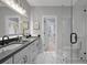 Elegant bathroom with double sinks, granite counters, tile flooring, and a glass shower at 458 Connally Se St, Atlanta, GA 30312