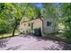 View of the home's backyard, featuring a white brick exterior, deck, and lush green trees and landscaping at 481 Meadowbrook Se Dr, Marietta, GA 30067