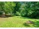 Lush backyard with mature trees, grassy lawn, and wooden steps leading to a serene outdoor space at 481 Meadowbrook Se Dr, Marietta, GA 30067