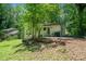 Exterior view of the backyard, featuring the home, a deck, and green trees for added privacy at 481 Meadowbrook Se Dr, Marietta, GA 30067