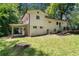 Exterior view of the home featuring a covered parking area and expansive grassy backyard with mature trees at 481 Meadowbrook Se Dr, Marietta, GA 30067