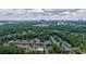 An aerial view shows the neighborhood surrounded by mature landscaping and the city skyline in the background at 6851 Roswell Rd # G3, Atlanta, GA 30328