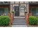 Welcoming entryway with brick accents, planters, and decorative sconces creating a warm arrival at 6851 Roswell Rd # G3, Atlanta, GA 30328