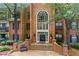 An elegant brick building exterior with a grand entrance, complemented by manicured landscaping and mature trees at 26303 Plantation Ne Dr # 303, Atlanta, GA 30324