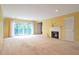 Bright living room with a fireplace, sliding glass doors to a balcony, and yellow walls at 26303 Plantation Ne Dr # 303, Atlanta, GA 30324