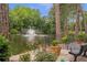 A serene pond view with a central fountain, lush trees, flowers and benches create a park-like atmosphere at 26303 Plantation Ne Dr # 303, Atlanta, GA 30324