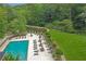 Community pool, patio, and grilling area overlooking a pond and manicured grounds at 26303 Plantation Ne Dr # 303, Atlanta, GA 30324