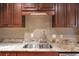 The kitchen features a stainless steel sink with a granite countertop and dark wood cabinetry at 26303 Plantation Ne Dr # 303, Atlanta, GA 30324