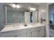 Bathroom with double sinks, white cabinets and countertop, large mirror, and a view of the main bedroom at 2870 Livsey Woods Dr, Tucker, GA 30084