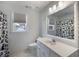 Bright bathroom with white vanity, toilet, and patterned shower curtain with hexagon tile floor at 2870 Livsey Woods Dr, Tucker, GA 30084