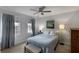 Bedroom with a ceiling fan, two windows with curtains, a bed, a dresser and a bench at 2870 Livsey Woods Dr, Tucker, GA 30084