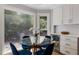 Inviting breakfast nook with a glass table, blue velvet chairs, built-in storage, and large windows overlooking the yard at 2870 Livsey Woods Dr, Tucker, GA 30084