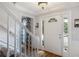 Bright entryway with a white staircase, wainscoting, crown molding, and wood-look flooring at 2870 Livsey Woods Dr, Tucker, GA 30084