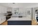 Bright kitchen boasts white cabinets, stainless appliances, gray countertops, and a stylish blue island with marble countertop at 2870 Livsey Woods Dr, Tucker, GA 30084