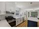 Modern kitchen featuring white cabinets, stainless steel appliances, a herringbone backsplash, and a center island at 2870 Livsey Woods Dr, Tucker, GA 30084
