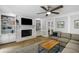 Cozy living room featuring a fireplace, built-in bookshelves, neutral colors, and a ceiling fan at 2870 Livsey Woods Dr, Tucker, GA 30084