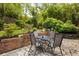 Backyard patio with stone flooring featuring four chairs and a table and various potted plants at 2870 Livsey Woods Dr, Tucker, GA 30084