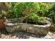 Stone backyard pond featuring a small waterfall and various plants at 2870 Livsey Woods Dr, Tucker, GA 30084
