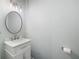 Stylish bathroom with a modern sink, vanity, and a large round mirror at 403 Village Vw, Woodstock, GA 30188