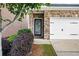 Home entrance features a black door with decorative glass insert, complemented by lush landscaping at 403 Village Vw, Woodstock, GA 30188