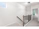 Upstairs hallway features carpeted floors and a black metal railing on wood banisters at 403 Village Vw, Woodstock, GA 30188