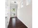 Hallway view shows hardwood floors, neutral wall color, white trim and a door with decorative glass insert at 403 Village Vw, Woodstock, GA 30188
