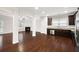Open concept with hardwood floors, kitchen with stainless appliances, and living room with fireplace at 403 Village Vw, Woodstock, GA 30188