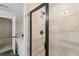Modern bathroom features tiled shower with glass door, tub and geometric wallpaper accent at 4967 Zoya Sw Ct, Atlanta, GA 30331
