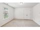 Neutral bedroom featuring plush carpet, large window, and double door closet at 4967 Zoya Sw Ct, Atlanta, GA 30331