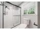Bathroom featuring a tiled shower, glass enclosure and window with bright light at 2173 Tanglewood Ne Trl, Conyers, GA 30013