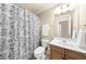 Bathroom with floral shower curtain and vanity with wooden cabinets at 2685 Gateview Ct, Cumming, GA 30040