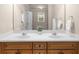 Bathroom featuring a dual-sink vanity with wooden cabinets and a large mirror at 2685 Gateview Ct, Cumming, GA 30040