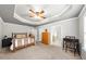 Spacious bedroom with neutral walls, tray ceilings, and an ensuite bathroom at 2685 Gateview Ct, Cumming, GA 30040