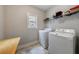 Bright laundry room with a window, shelving, tile floors, a folding table, and a new washer and dryer at 3018 Patriot Square, Marietta, GA 30064
