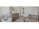 A calming Bedroom featuring a gray crib, dresser with changing station, decorative mirrors, and accent chair at 5451 Baybrook Cir, South Fulton, GA 30349