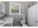 Neutral bathroom featuring a single sink vanity, toilet, shower with curtain, and window at 210 Evans Dr, Decatur, GA 30030