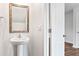 Bathroom features a pedestal sink and an ornate mirror with modern fixtures at 5449 Baybrook Cir, South Fulton, GA 30349