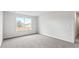 Sunlit bedroom with neutral carpet, white walls, and a large window offering a view of the outdoors at 5449 Baybrook Cir, South Fulton, GA 30349
