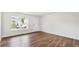 Bright living room with hardwood floors, white walls, large window, and a white front door at 5449 Baybrook Cir, South Fulton, GA 30349