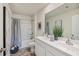 Bright bathroom featuring a double vanity, shower/tub combo with a gray curtain, and neutral walls at 5455 Baybrook Cir, South Fulton, GA 30349
