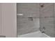 Light grey tiled shower over tub with niche shelf and chrome shower head at 250 Stonecreek Pkwy, Covington, GA 30016