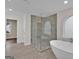 Modern bathroom features a soaking tub, a glass enclosed shower and neutral tile at 250 Stonecreek Pkwy, Covington, GA 30016