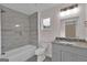 Bathroom with tiled shower over tub, toilet, window, and a vanity with grey stone countertop at 250 Stonecreek Pkwy, Covington, GA 30016