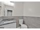 Bathroom featuring toilet, light grey tiled accent wall, and vanity with stone countertop at 250 Stonecreek Pkwy, Covington, GA 30016