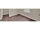 Corner view of a bedroom showing new wood flooring, white base trim and a window at 250 Stonecreek Pkwy, Covington, GA 30016
