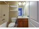Bathroom with single vanity, tub with shower, toilet and open shelving at 275 Autry Mill Ln, Suwanee, GA 30024