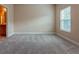 Empty bedroom with light carpet, neutral walls, and a large window for natural light at 275 Autry Mill Ln, Suwanee, GA 30024