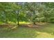 View of large backyard with mature trees and a shed in a park-like setting at 676 Smith Store Rd, Covington, GA 30016