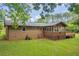 Backyard view of a charming brick home with a screened porch and wooden deck at 676 Smith Store Rd, Covington, GA 30016